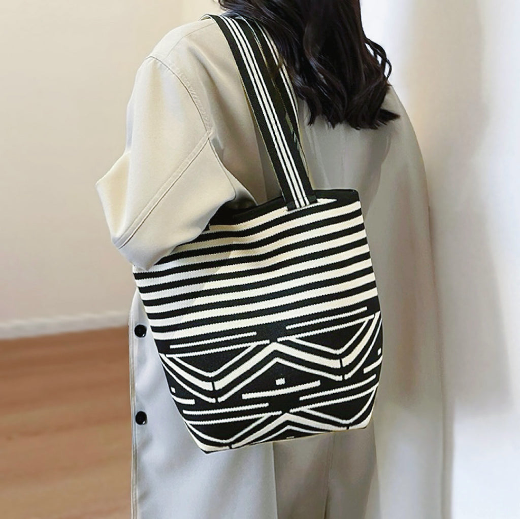 Close-up of the artistic pattern bucket bag being worn on the shoulder.