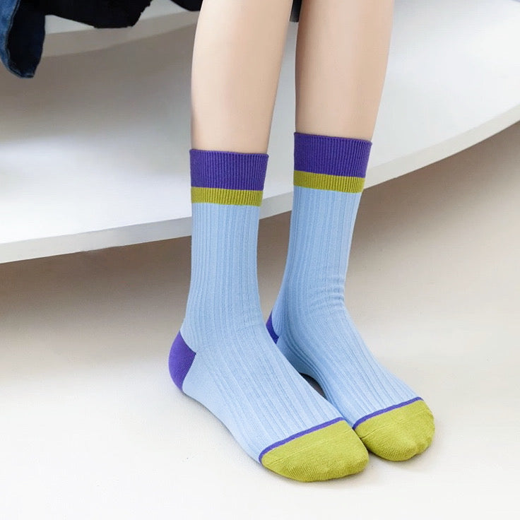 Model wearing a pair of Bold Clash Socks in blue, ideal for workouts and commuting.