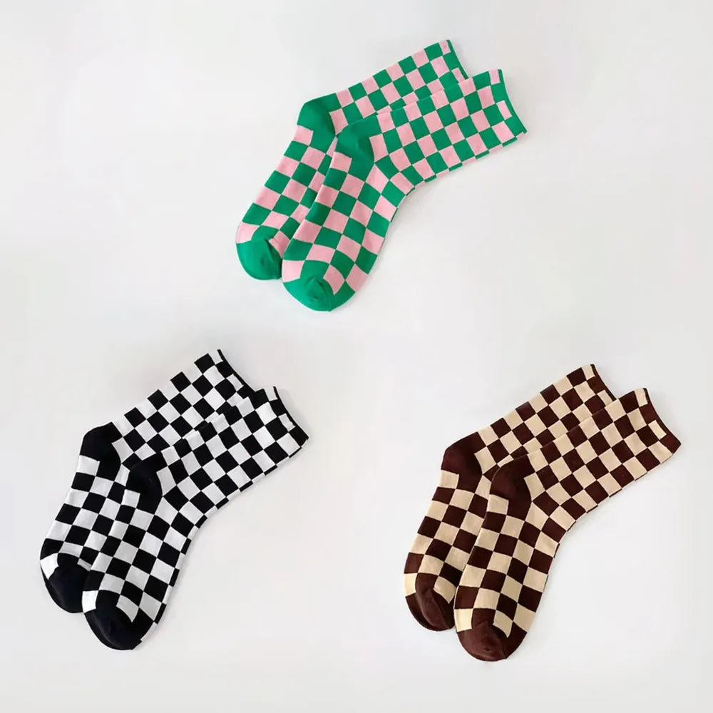 Flat lay of 3 pairs of Checkerboard Colored Socks, green, black and brown.