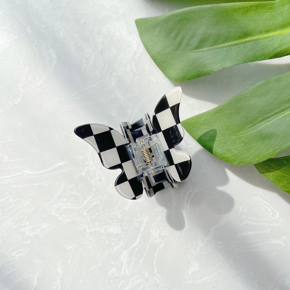Folded view of checkered hair claw in butterfly shape , ideal for quick updos and ponytails.