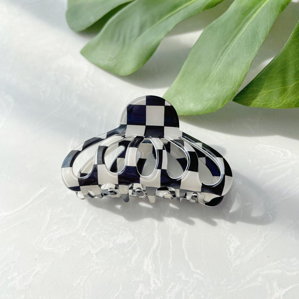 Flat lay of checkered hair claw hair claw clip in lantern shape, great for everyday styling and gifting.