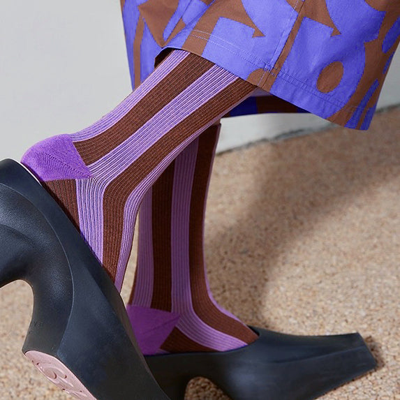 Model wearing a pair of Contrast Color Striped Socks in purple, easy to pack for travel and errands.