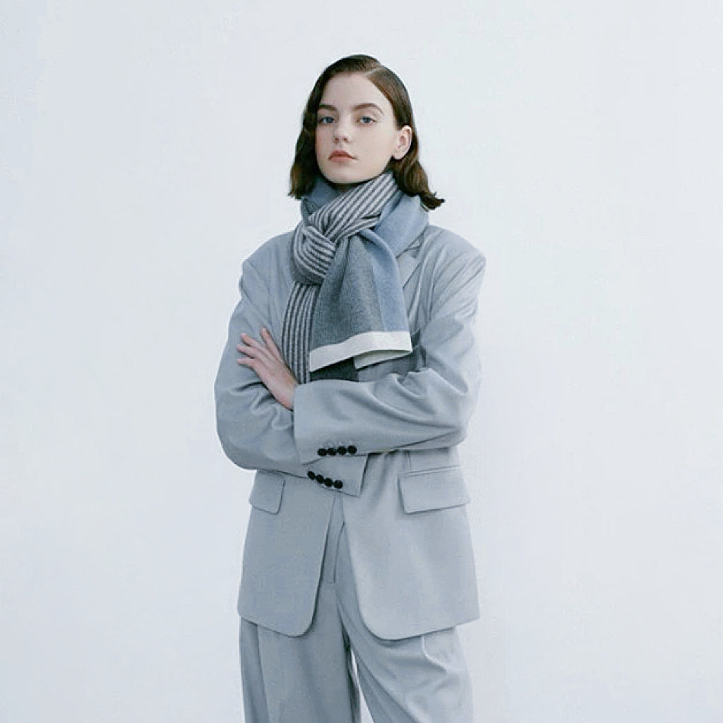 Model wearing a striped scarf in gray and blue, easy for weekend styling and gifting.