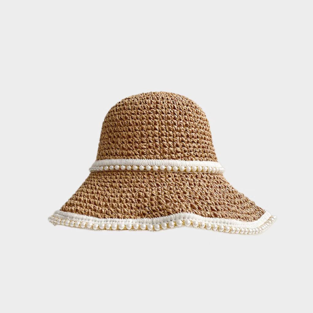 Front view of khaki straw hat and shimmering pearl band presenting elegant coastal accessory.