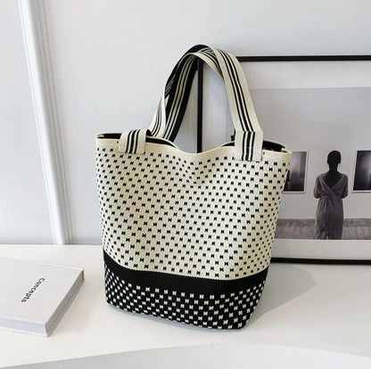 Cream-colored bucket bag with black dotted and striped artistic patterns.