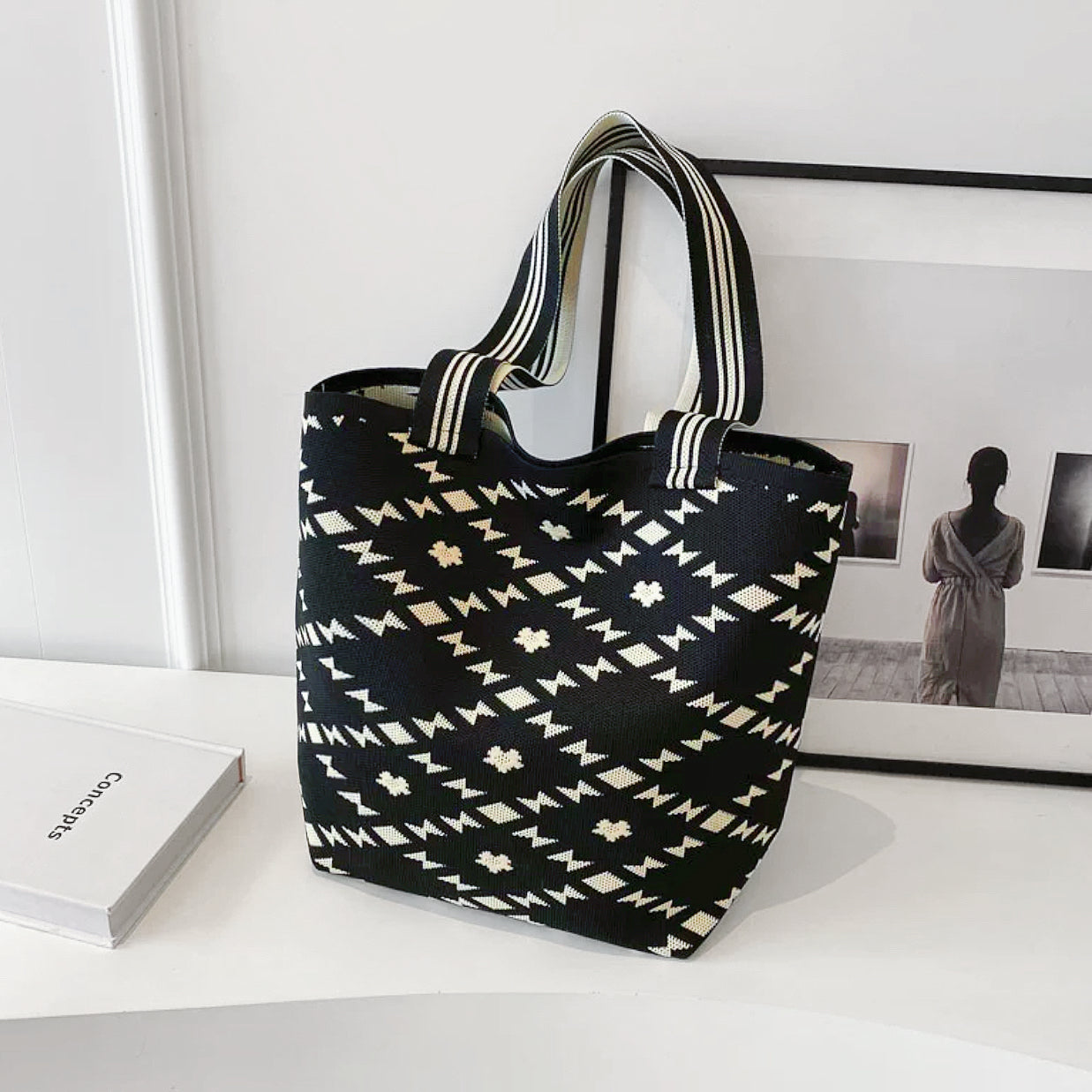 Front view of the black bucket bag with diamond geometric artistic patterns.