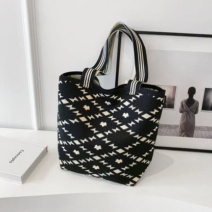 Front view of the black bucket bag with diamond geometric artistic patterns.