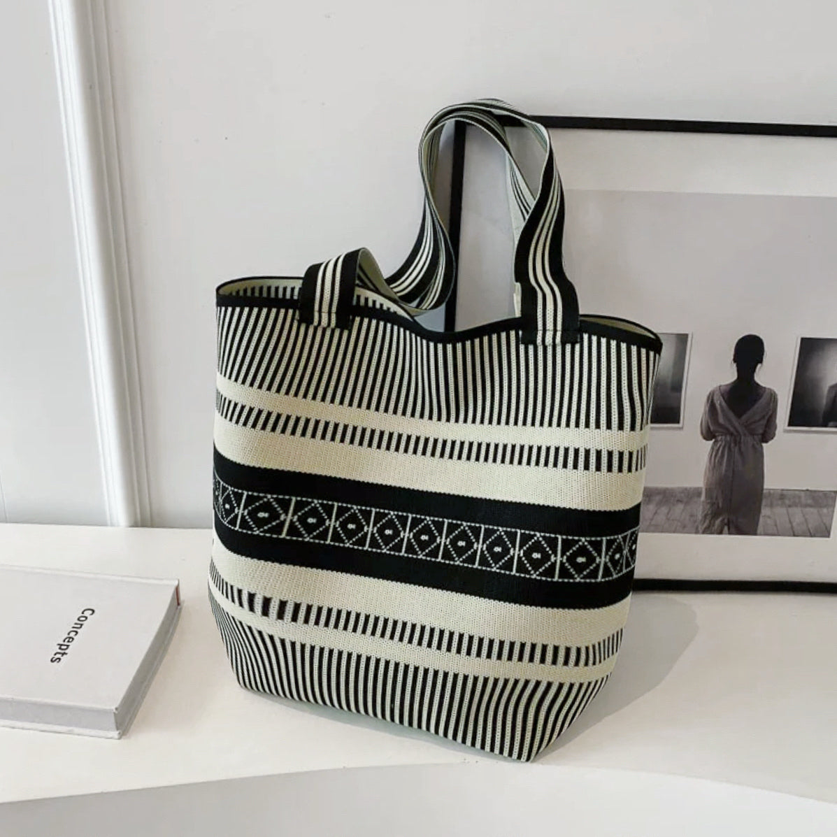 Front view of the artistic pattern bucket bag with bold black and white stripes and geometric details.