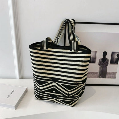 Artistic bucket bag featuring a complex mix of horizontal stripes and geometric patterns.
