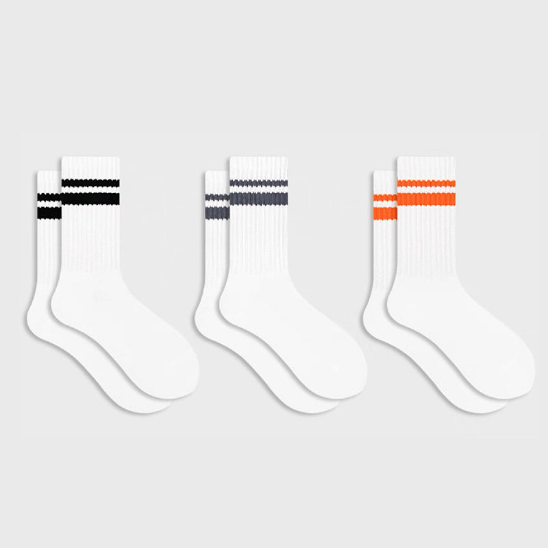 Flat lay of 3 colors of Athletic Striped Slouch Socks, black, orange and gray.