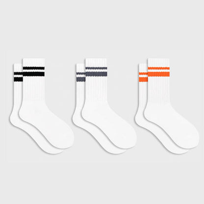 Flat lay of 3 colors of Athletic Striped Slouch Socks, black, orange and gray.