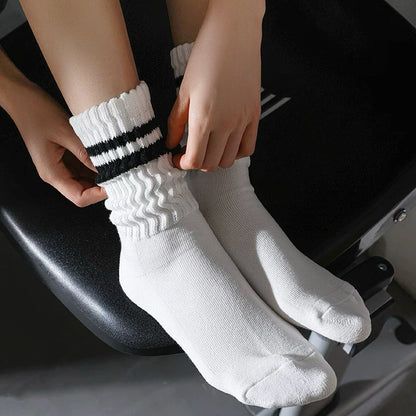 Model wearing a pair of black Athletic Striped Slouch Socks , easy for travel days and daily comfort.