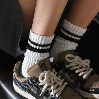 Model wearing a pair of black Athletic Striped Slouch Socks, ideal for everyday outfits and sneakers.