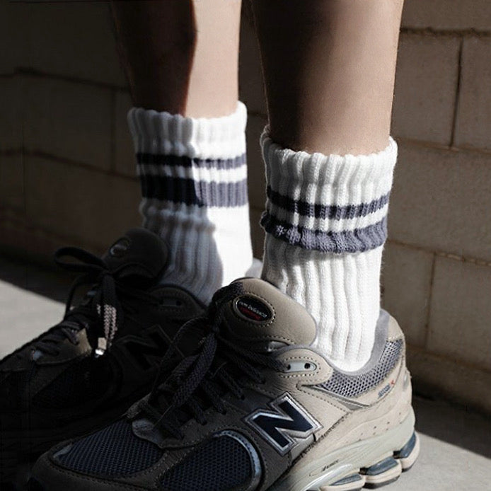 Model wearing a pair of Athletic Striped Slouch Socks in gray, ideal for workouts and commuting.