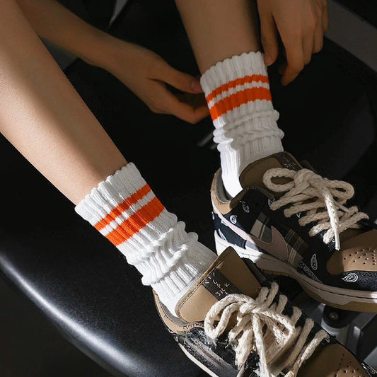 Model wearing a pair of orange striped cotton socks, ideal for everyday outfits and sneakers.