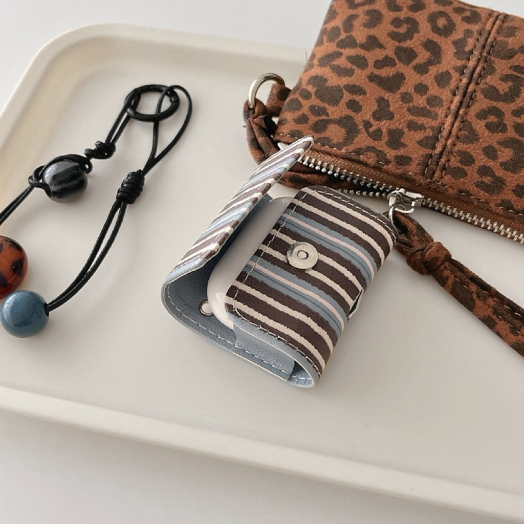 Flat lay of Beaded Melody Wrap Airpods Case Cover with the separated strap.