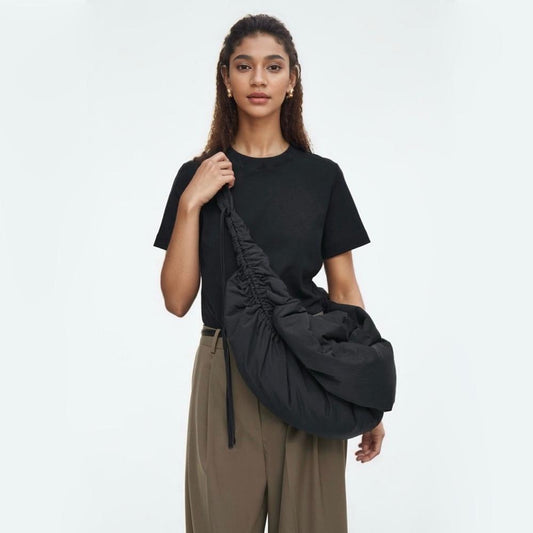 Model wearing the oversized black duvet crescent bag, showcasing its large, slouchy fit.