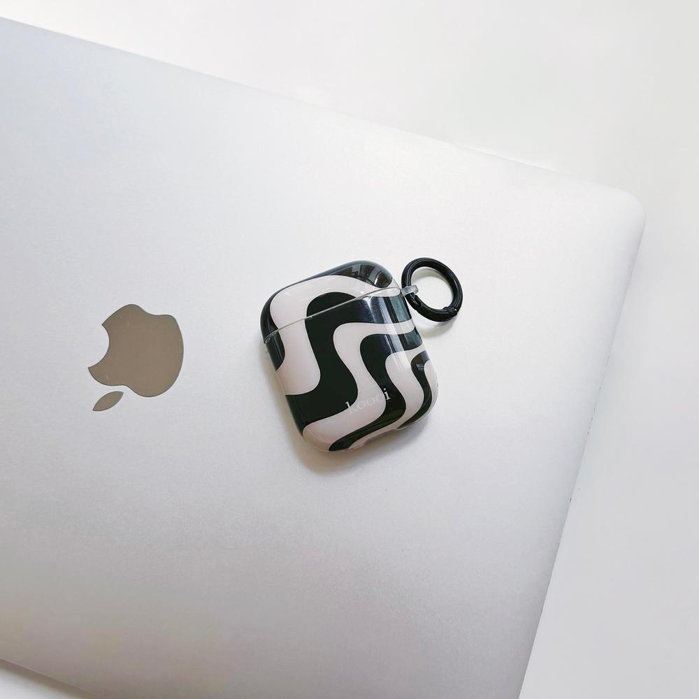 Flat lay of Black Wave Airpods Case Cover, great for daily protection and travel.