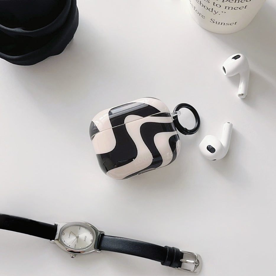 Front view of Black and white wavy silicone AirPods case cover with a black keyring, next to white AirPods.