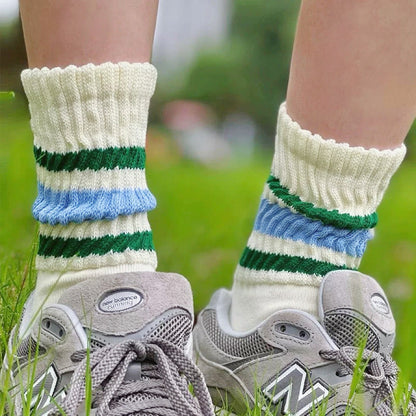 Model wearing a pair of Blockcore Slouch Socks in blue and green, ideal for workouts and commuting.