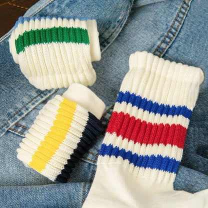 Three pairs of White Blockcore Slouch Socks with colorful stripes on ribbed cotton-polyester fabric.