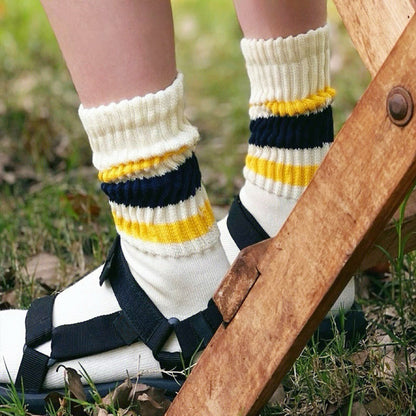 Model wearing a pair of blockcore slouch socks in yellow and blue, ideal for everyday outfits and sneakers.