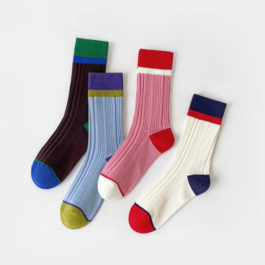 Front view of Four pairs of ribbed cotton-polyester Bold Clash Socks in various color block designs.