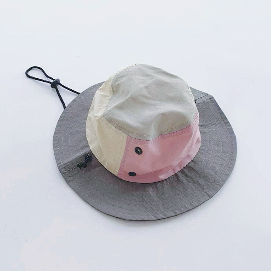 Flatlay of the grey and pink plant-inspired brimmed hat on a white background.