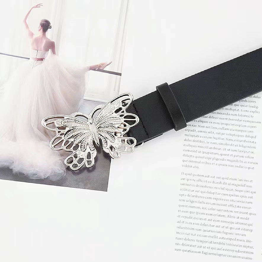 Close-up of the sleek belt with silver metal butterfly buckle.