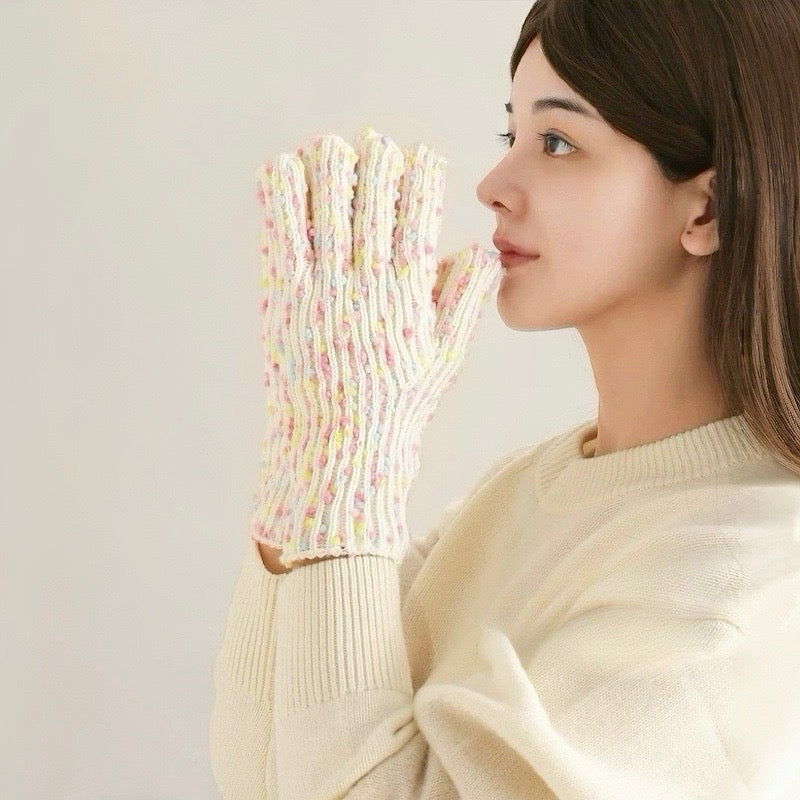 Model wearing cream candy-dot knit gloves with multicolor raised dots; soft knit for cold-weather outings.