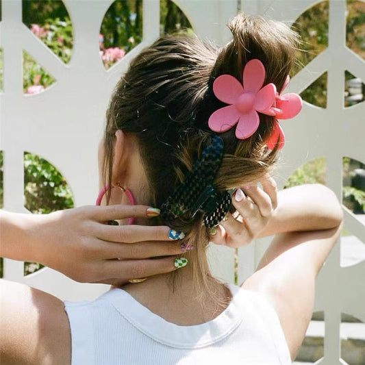 Model wearing a Pink acrylic flower hair claw, showcasing vacation style.