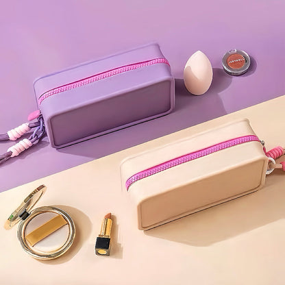 Top and side view of purple and khaki silicone cosmetic pouches displaying the smooth zip-top fastening.