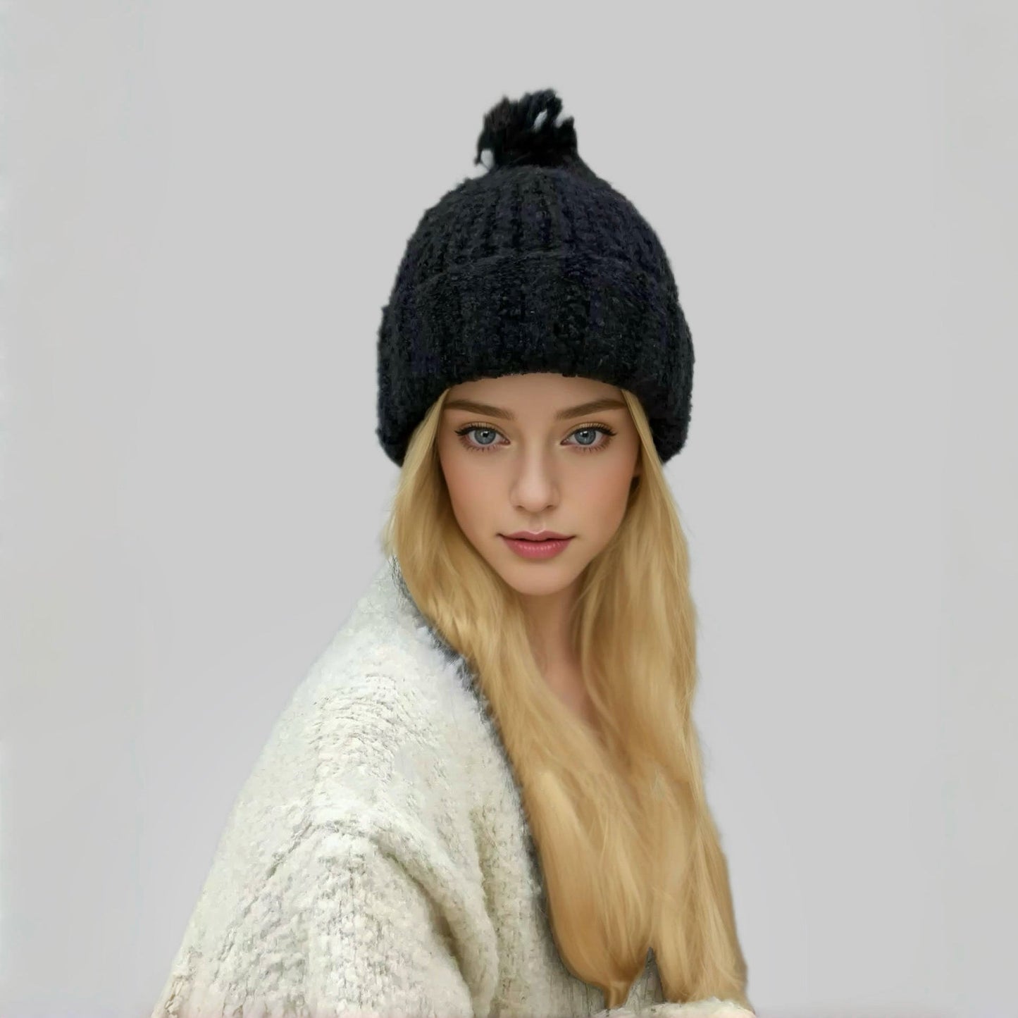 Model wearing black Candy Knitted Pompom Beanie. Playful 3D pompom detail in soft-touch knit.