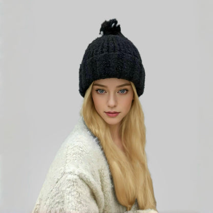 Model wearing black Candy Knitted Pompom Beanie. Playful 3D pompom detail in soft-touch knit.