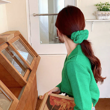 Model wearing a Candy Knitted Scrunchie in green, great for everyday styling and gifting.