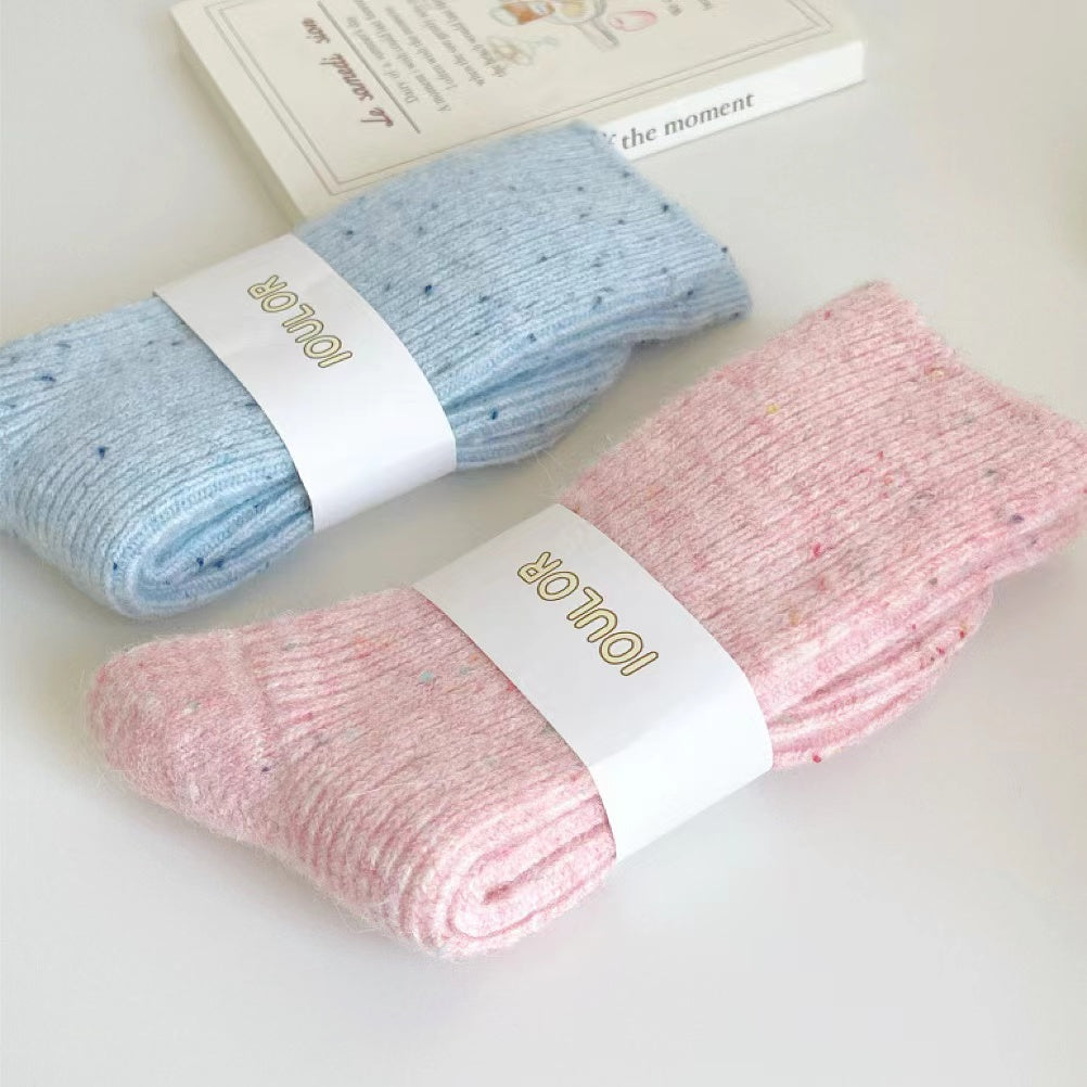 Close-up of the thermal knit texture on the pink and blue candy wool socks.