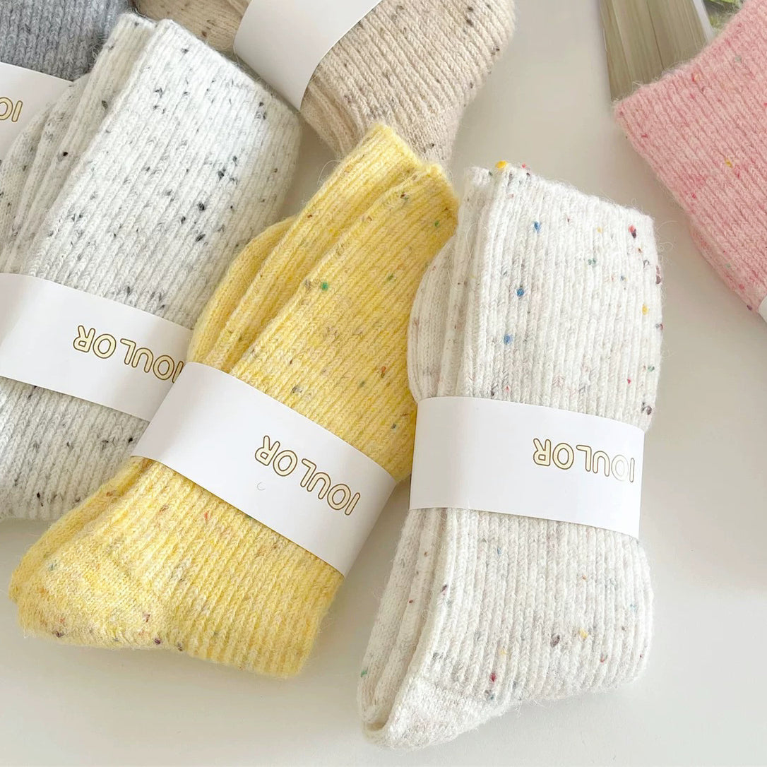 several pairs of white and yellow wool socks displayed flat.