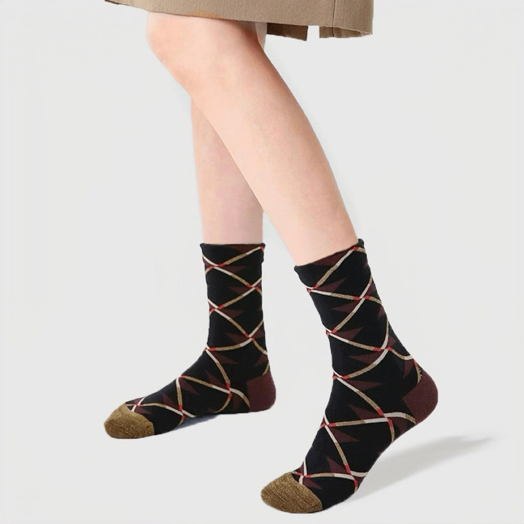Angled view of Caramel Diamond Socks: Black cotton-polyester socks with intersecting caramel, white, and red lines.