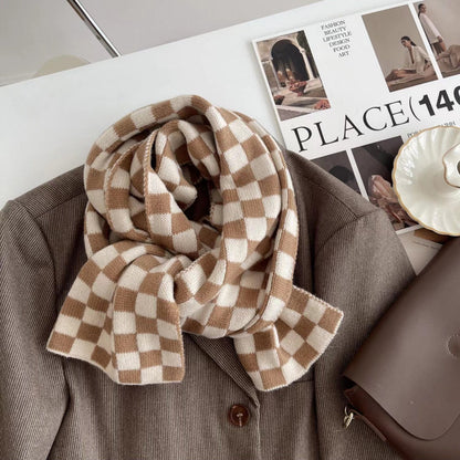 Close-up of  a plaid scarf in beige and khaki draped over a brown blazer, great for office layering and commuting.
