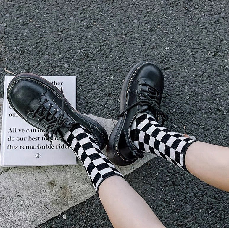 Model wearing a pair of black plaid cotton socks, great for casual wear and light workouts.
