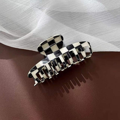 Folded view of checkerboard hair claw in cross shape, great for everyday styling and gifting.