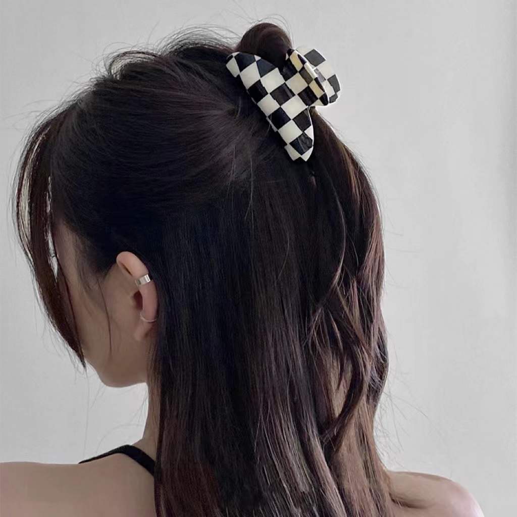 Model wearing checkerboard hair claw in curve shape, great for everyday styling and gifting; for office.