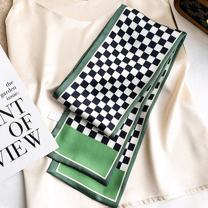 Model wearing a Green and white checkerboard satin skinny scarf on a light top, great for office.