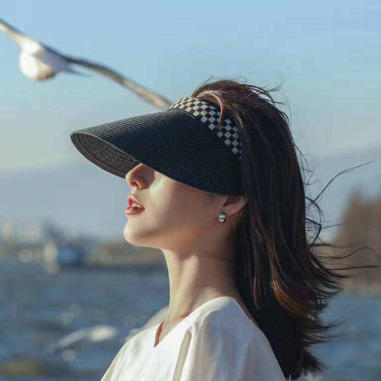 Side view of model wearing black Checkered Band Straw Visor Hat for summer sun protection.
