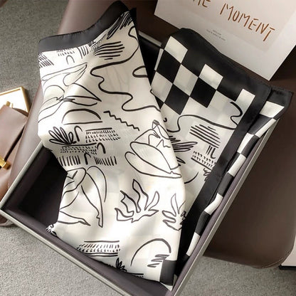 Front view of Satin square scarf with abstract black and white patterns and a checkered border, great for office.