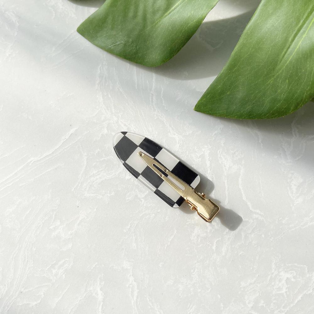 Front view of checkered hair claw in arrow shape, easy for workdays and special occasions.