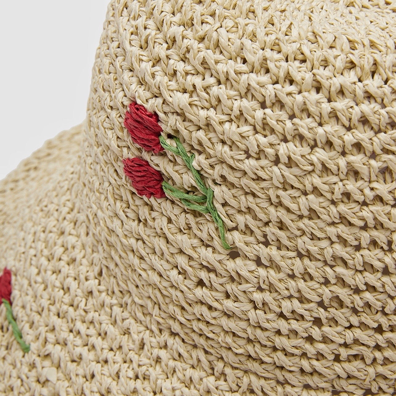 Close-up of the high-quality straw material and cherry embroidery detail.