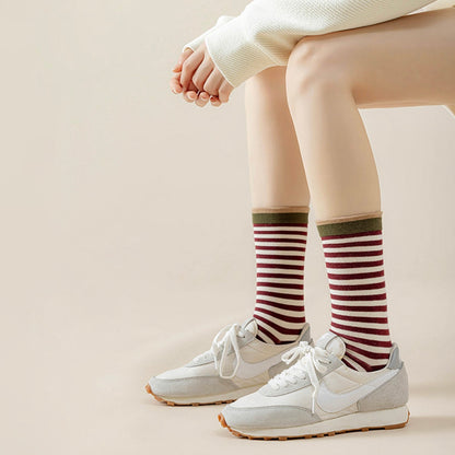 Model wearing a pair of Chromatic Stripe Socks in burgundy, great for daily wear and lounging.