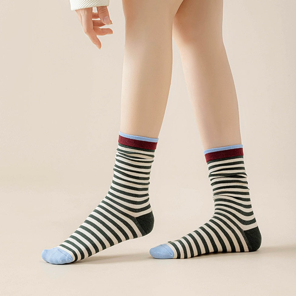 Model wearing a pair of green striped socks, great for casual wear and light workouts.