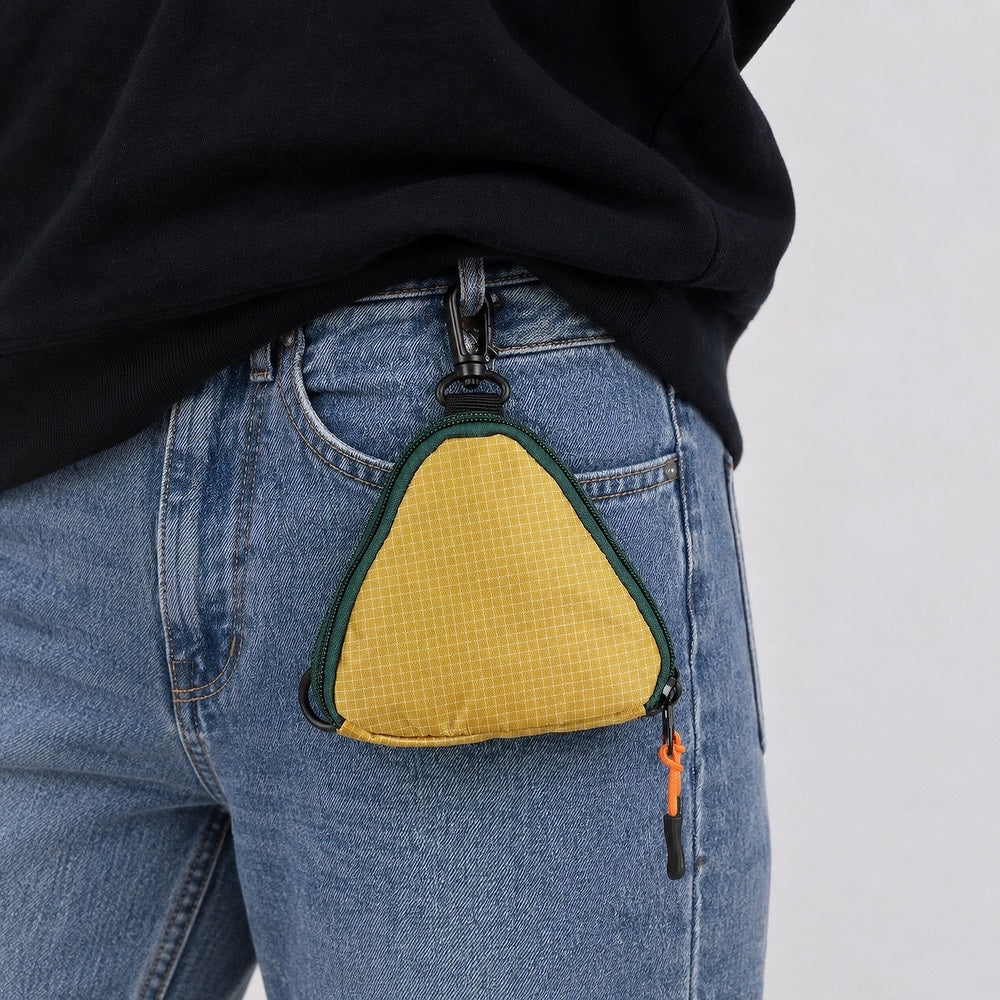 Close-up of a triangle multi-use bag clipped to a belt loop, showing hands-free storage for keys and cards.